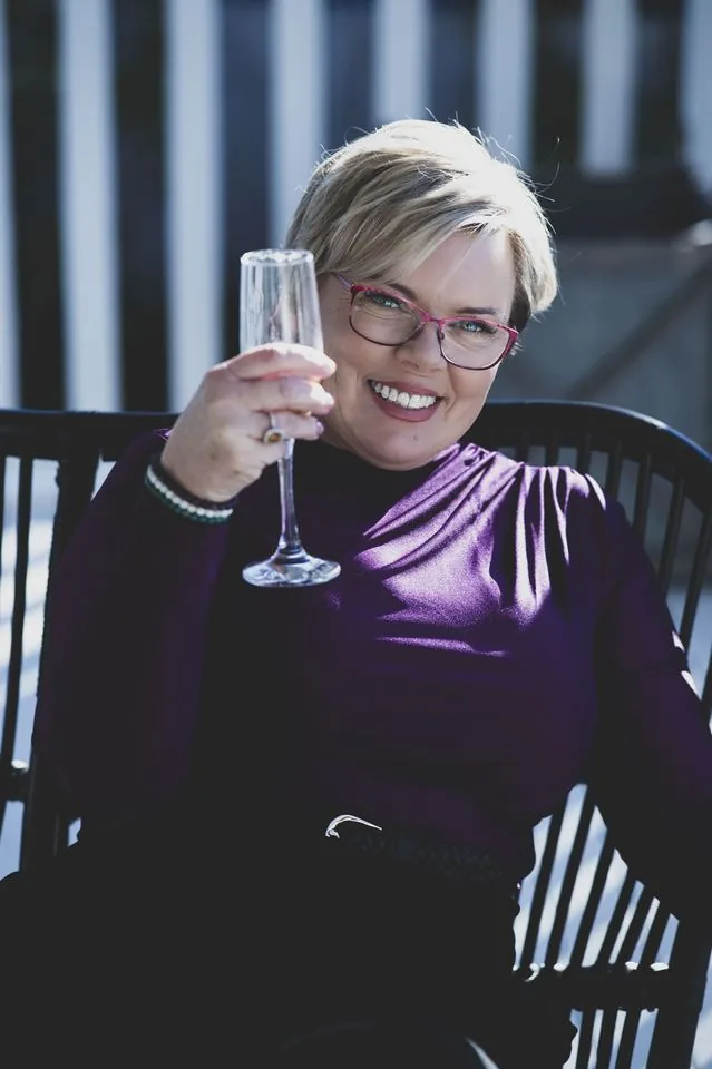 Catheryn Wright raising a glass to celebrate