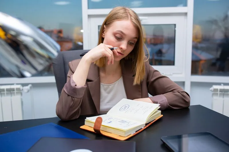 Business owner planning her exit strategy with a notebook at her desk
