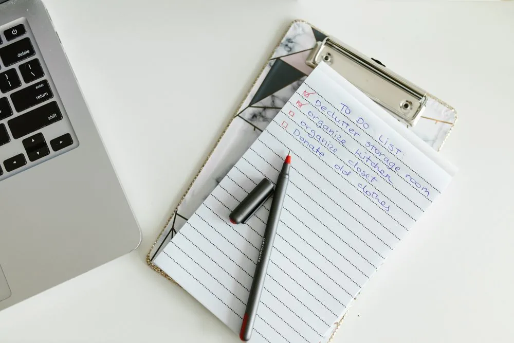 To-do checklist on a clipboard beside a laptop